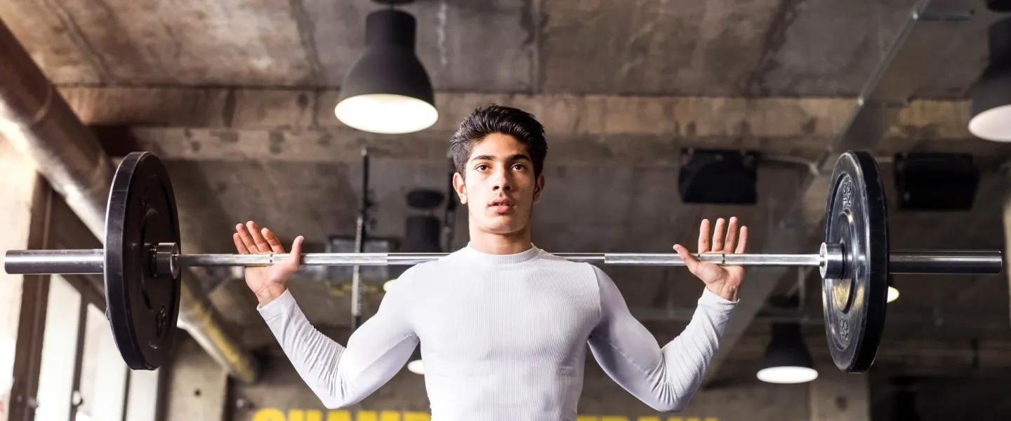 Teen Squatting Lifting Weights